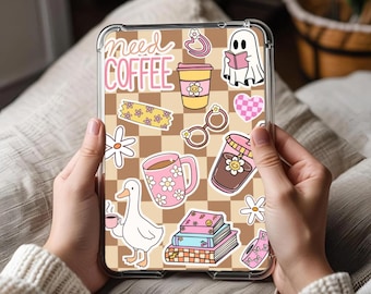 Op de afbeelding: Een doorzichtige tablethoes met een bruin en beige ruitpatroon en diverse stickers. Stickers zijn onder meer een koffiekopje, een spook dat een boek leest, madeliefjes en de tekst "need COFFEE".