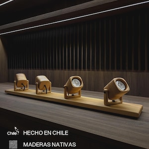 Puede incluir: Cuatro focos de madera montados sobre una base de madera. Cada foco tiene forma cilíndrica con una bombilla en su interior. Los focos son de madera clara y están dispuestos en fila. El texto "HECHO EN CHILE" es visible.
