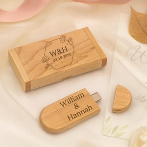Puede incluir: Una memoria USB de madera y su caja a juego. La caja es rectangular con las iniciales "W&H" y la fecha "03.19.2025" grabadas en la tapa. La memoria USB está grabada con los nombres "William & Hannah".