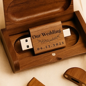 Könnte beinhalten: Ein USB-Stick aus Holz mit der Gravur "Our Wedding" und dem Datum "06.22.2025". Der USB-Stick befindet sich in einer passenden Holzbox. Die Box ist geöffnet und zeigt den USB-Stick und seinen Anschluss.