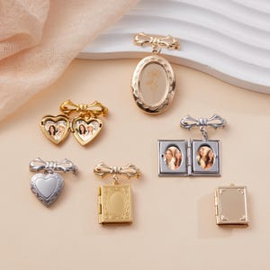 May include: Collection of various metal lockets in gold and silver tones. The lockets are in different shapes, including hearts, ovals, and books. Some lockets are open, revealing small photographs. Each locket has a decorative bow at the top.