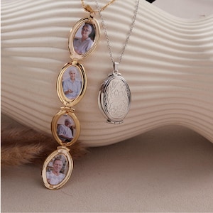 May include: Two oval-shaped locket necklaces. One is gold-toned, opening to reveal three oval photo frames. The other is silver-toned, with a floral design on the front. Both hang on delicate chains, showcasing a classic jewelry design.