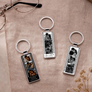 Puede incluir: Tres llaveros rectangulares de metal plateado con diseño de tira de película y fotografías en blanco y negro de parejas. Cada llavero incluye una anilla y el texto You & Me o Together is my favorite place to be.