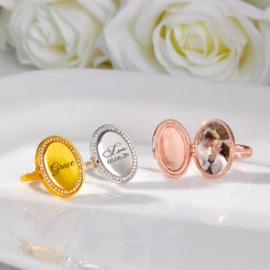 May include: A white ceramic mug with a black handle and the text "But First, Coffee" in a bold, black font. The mug is set against a blurred background, suggesting a cozy setting.