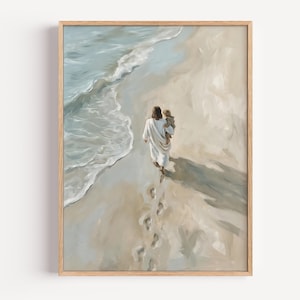 Puede incluir: Una impresión artística enmarcada que presenta una pintura al óleo de una figura con túnica blanca cargando a un niño pequeño a lo largo de una playa de arena. La escena muestra las olas del océano llegando a la orilla con huellas en la arena.