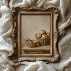 May include: A framed still life painting depicts two woven baskets on a wooden surface. One basket holds several round loaves of bread, and the other contains small fish. The frame is ornate with a light brown finish.