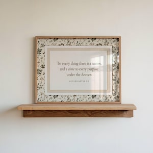 Peut inclure: Une impression encadrée rectangulaire avec une bordure à motif floral dans des tons de vert et de brun. Le centre affiche le texte : To every thing there is a season, and a time to every purpose under the heaven. ECCLESIASTES 3:1 en noir.