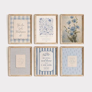May include: A set of six framed wall art prints featuring blue and white patterns, floral illustrations, and religious text including You Are God's Masterpiece, Lamentations 3:22-23, Be Still and Know That I Am God, and Psalm 61:2 in a light wood frame.