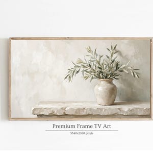 May include: A framed digital art print featuring a beige vase with green leafy branches on a stone ledge. The background is a neutral, textured wall. The frame is light brown. Text at the bottom reads "Premium Frame TV Art".