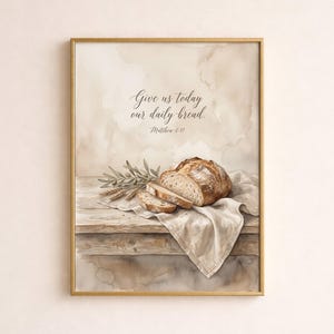 May include: Watercolor print of a loaf of bread, partially sliced, on a wooden table with a linen cloth. Olive branches and wheat stalks are also present. The text "Give us today our daily bread. Matthew 6:11" is written at the top.