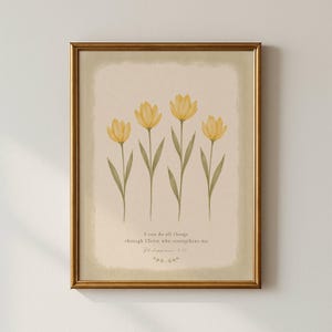 Pode incluir: Uma impressão de arte emoldurada com quatro flores amarelas semelhantes a tulipas, com caules e folhas verdes sobre um fundo creme. Abaixo das flores, o texto diz: I can do all things through Christ who strengthens me. Philippians 4:13.