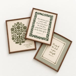 May include: Three rectangular wall art prints in dark wood frames. One features a green floral illustration with the text "With God all things are possible. Matthew 19:26". Another has a green leafy border with "And whatsoever ye do in word or deed, do all in the name of the Lord Jesus, giving thanks to God and the Father by him. Colossians 3:17". The third has green stripes and the text "The joy of the Lord is your strength. Nehemiah 8:10".