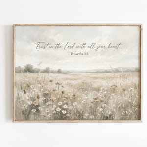 Può includere: Una stampa incorniciata raffigurante un paesaggio sereno di un campo di fiori selvatici in tonalità neutre. L'opera d'arte include il testo "Trust in the Lord with all your heart. - Proverbs 3:5" in elegante scrittura, perfetta per l'arredamento della casa.