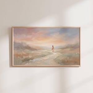 K&ouml;nnte beinhalten: Ein &Ouml;lgem&auml;lde in einem hellen Holzrahmen zeigt eine Figur, die auf einem Pfad durch eine Landschaft geht. Der Himmel geht von Pfirsich zu Blau &uuml;ber. Das Kunstwerk weckt ein Gef&uuml;hl von Frieden und Gelassenheit.