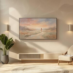 K&ouml;nnte beinhalten: Ein abstraktes Landschaftsgem&auml;lde in einem schwarzen Rahmen h&auml;ngt an einer beigen Wand. Das Kunstwerk zeigt eine Figur, die auf einem Weg auf einen farbenfrohen Sonnenuntergang zugeht. Darunter ein moderner, heller Holzschrank und ein Stuhl mit cremefarbenem Kissen.