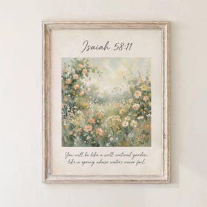 May include: A framed art print with a floral garden scene in pastel hues. The print includes the text "Isaiah 58:11" and a quote, set within a light wooden frame. The artwork evokes a sense of tranquility and natural beauty.