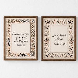 Peut inclure: Deux cadres muraux en bois foncé. L'impression de gauche présente une bordure florale et le texte : Consider the lilies of the field, how they grow. Matthew 6:28. L'impression de droite présente une bordure d'oiseaux et de fleurs avec le texte : Look at the birds of the air... Matthew 6:26.