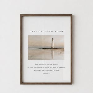 Puede incluir: Una lámina enmarcada con un faro de estilo acuarela en la orilla. El texto dice: THE LIGHT OF THE WORLD, seguido de la escritura: I AM THE LIGHT OF THE WORLD: HE THAT FOLLOWETH ME SHALL NOT WALK IN DARKNESS, BUT SHALL HAVE THE LIGHT OF LIFE. JOHN 8:12.