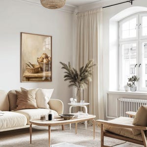May include: A cozy living room scene with a beige sofa, wooden coffee table, and a framed artwork. The artwork depicts a still life of bread and fish in baskets. A large window with cream-colored curtains provides natural light.