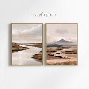 Könnte beinhalten: Ein Set aus zwei rechteckigen Wandbildern in Goldrahmen. Der linke Druck zeigt einen gewundenen Fluss durch eine Landschaft mit dem Text My help cometh from the Lord which made heaven and earth. Der rechte Druck zeigt Berge mit dem Text The mountains shall bring peace to the people.