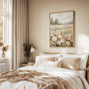 May include: A bedroom scene featuring a bed with white linens and beige pillows and throw. A framed painting of a field of flowers hangs above the bed. The room has beige curtains and a small table with a lamp.