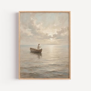 Pode incluir: Uma impressão de arte de parede emoldurada retratando uma figura com uma túnica branca em pé num pequeno barco a remos de madeira sobre uma massa de água calma. A cena passa-se sob um céu suave e nublado ao nascer do sol, com tons bege e azuis.