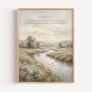 May include: A framed landscape print featuring a serene river scene with fields and trees in muted tones. The artwork includes the text "PSALM 27:1" and a Bible verse. The print is encased in a light brown wooden frame.