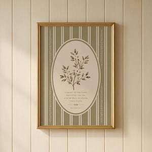 May include: A framed wall art print featuring a sage green background with vertical white stripes and a central oval containing a botanical illustration of a leafy branch. The text reads: Commit to the Lord whatever you do, and he will establish your plans. Proverbs 16:3.