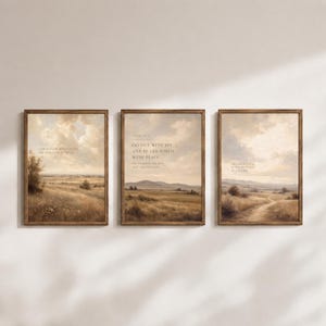 Può includere: Un set di tre stampe artistiche rettangolari con cornici in legno scuro, ognuna raffigurante un paesaggio con un campo dorato sotto un cielo nuvoloso. Le stampe contengono testo bianco con versetti biblici, tra cui Go out with joy.