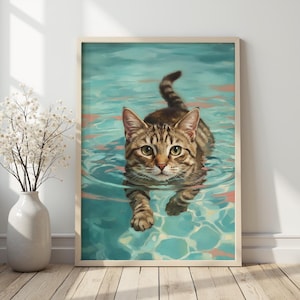 Könnte beinhalten: Ein gerahmter Kunstdruck einer getigerten Katze, die in einem Pool schwimmt. Die Katze hat braune und schwarze Streifen und blickt direkt den Betrachter an. Das Wasser ist hellblau mit Reflexen.