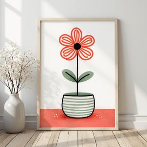 Könnte beinhalten: Ein gerahmter Kunstdruck mit einer stilisierten Blume in einem gestreiften Topf. Die Blume hat rote Blütenblätter und eine schwarze Mitte, mit grünen Blättern. Der Topf ist grün und weiß gestreift, vor einem weißen Hintergrund mit roter Basis.