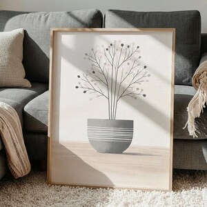 Könnte beinhalten: Ein gerahmter Kunstdruck mit einem minimalistischen Baumdesign. Das Kunstwerk zeigt einen Baum mit dünnen schwarzen Ästen und kleinen, dunkelgrauen kreisförmigen Blättern, gepflanzt in einem grauen Topf mit horizontalen weißen Streifen.