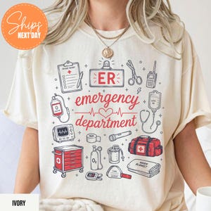 Puede incluir: Una camiseta color marfil con un estampado gr&aacute;fico de equipo m&eacute;dico de emergencia que incluye un informe de paciente, un letrero de ER, tijeras, radio, bolsa de suero, monitor card&iacute;aco, tanque de ox&iacute;geno y el texto ER emergency department.
