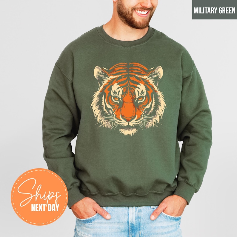 A man wearing a green sweatshirt with a graphic of a tiger's face printed on it.