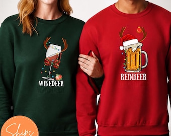 Puede incluir: Una sudadera verde bosque con una copa de vino con astas de reno y el texto Winedeer, y una sudadera roja con una jarra de cerveza con astas de reno, un gorro de Papá Noel y el texto Reinbeer, ambas con gráficos de luces navideñas de colores.