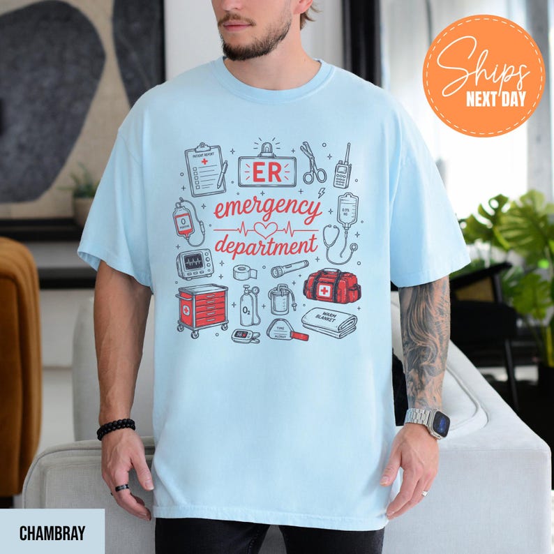 Puede incluir: Una camiseta azul claro con un estampado gr&aacute;fico de equipo m&eacute;dico y el texto "ER emergency department" junto a un coraz&oacute;n. El dise&ntilde;o incluye ilustraciones de un portapapeles, tijeras, una bolsa de suero, un monitor card&iacute;aco y un botiqu&iacute;n.