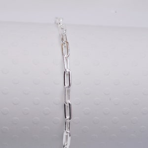May include: A silver chain bracelet with a delicate, linked design.