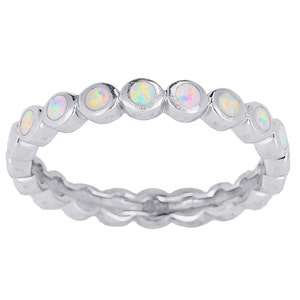 May include: A silver band ring with a row of white opal stones.