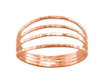 Könnte beinhalten: Ein roségoldener Hammerring mit vier übereinanderliegenden Bändern.