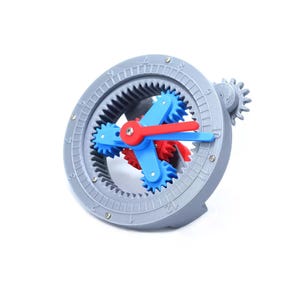 Pode incluir: Um relógio cinza impresso em 3D com engrenagens azuis e vermelhas. O mostrador do relógio tem números e pequenos detalhes prateados. Os ponteiros são vermelhos e azuis, e as engrenagens são visíveis.