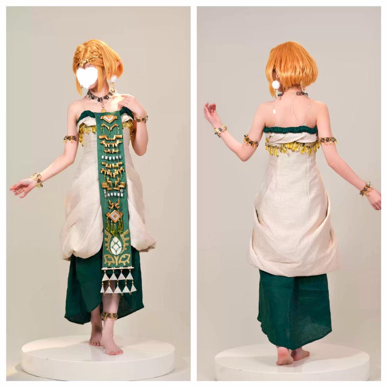 Op de afbeelding: Een kostuum bestaande uit een cr&egrave;mekleurig strapless lijfje met een donkergroen stoffen paneel aan de voorzijde, versierd met gouden geometrische accenten en hangende driehoekige bedels. De outfit bevat een donkergroene rok, gouden armbanden en een ketting.
