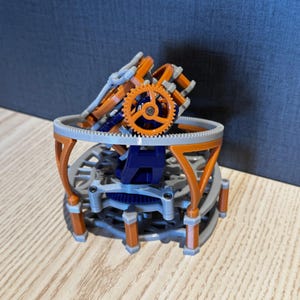 以下が含まれることがあります： 複雑な歯車システムと支持構造を備えた3Dプリントの機械モデル。オレンジ、グレー、ブルーのコンポーネントを使用し、上部に目立つオレンジ色の歯車があります。このデザインは、複雑なディテールと多層構造を示しています。