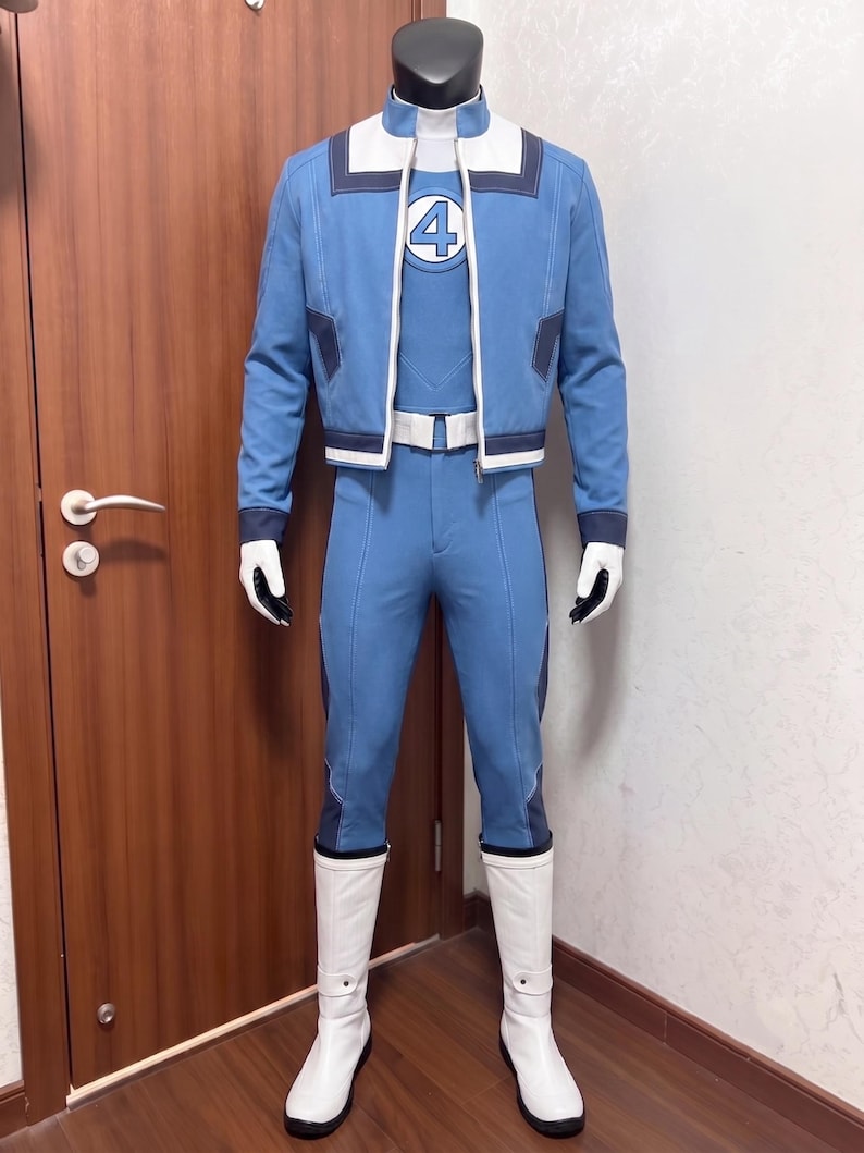 May include: A blue and white costume featuring a jacket with a number 4 emblem on the chest, matching blue trousers, a white belt, and white boots. The jacket has a high collar, dark blue accents, and a full-length zipper. The ensemble is displayed on a mannequin.