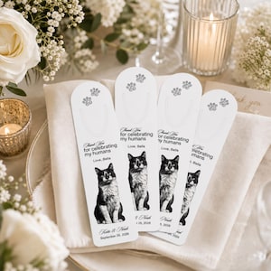 Può includere: Quattro etichette di carta bianca rettangolari e verticali con bordi arrotondati, ciascuna con un'illustrazione in bianco e nero di un gatto, due impronte di zampe e il testo stampato: Thank You for celebrating my humans, Love, Bella, Katie & Noah, September 26, 2026.