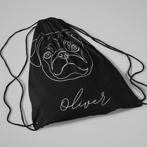 May include: Black drawstring backpack featuring a white line drawing of a pug's face. The name "Oliver" is written in cursive below the pug illustration. The bag has black drawstrings.