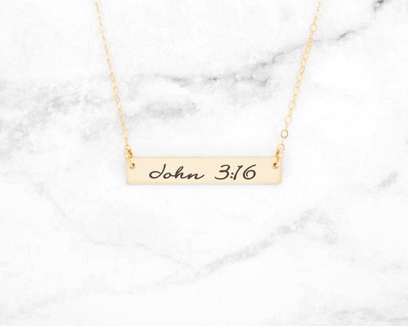 May include: Gold bar necklace with the words "John 3:16" inscribed on it.
