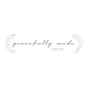Może przedstawiać: Logo firmy jubilerskiej o nazwie "gracefully made". Logo zawiera nazwę firmy w ozdobnym, pochylonym kroju pisma, z kwiatowym wzorem po obu stronach.