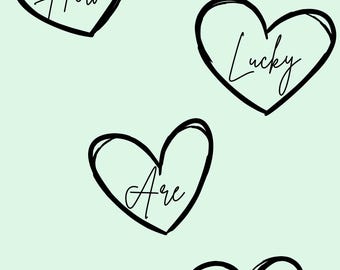 May include: A pale green background featuring four black heart shapes, each with a handwritten word inside. The words are "How", "Lucky", "Are", and "We", creating a simple message.