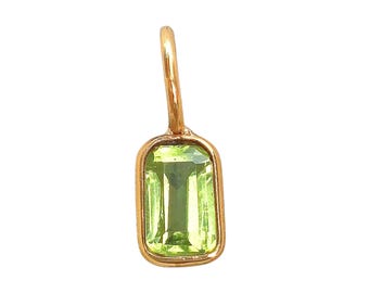 May include: A gold pendant featuring a rectangular, light green gemstone. The gemstone is set in a gold bezel and has a loop at the top for a chain. The pendant is approximately 1.9 cm long.