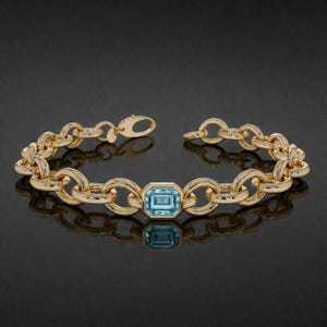 May include: A gold bracelet featuring a central, rectangular, light blue gemstone. The bracelet is composed of interlocking oval links. The clasp is open, revealing the closure mechanism.